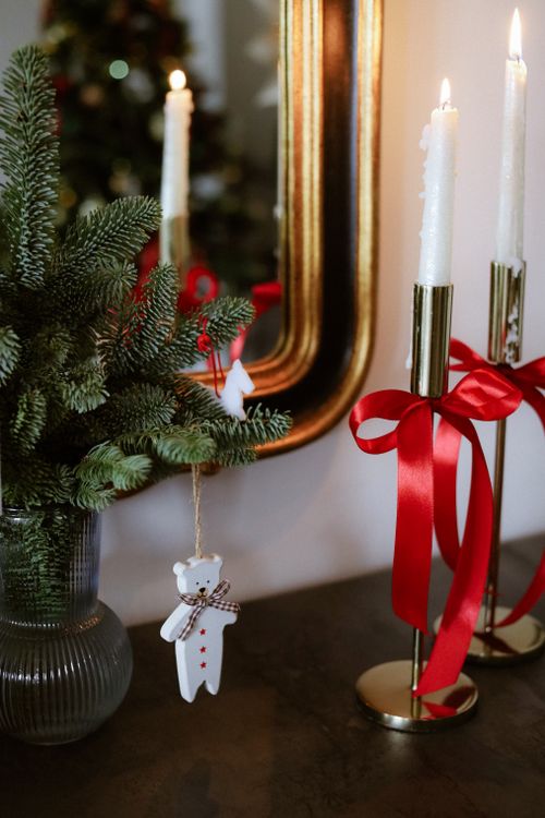 Free Elegant holiday decor with candles, red ribbons, and pine branches. Stock Photo