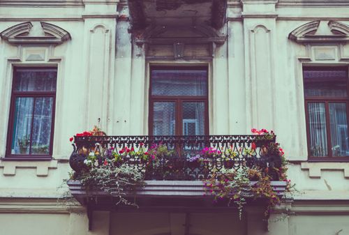 Free A beautiful vintage balcony adorned with colorful flowers and iron railing. Stock Photo