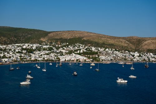 Free Aerial view of Bodrum harbor, Türkiye, with boats and whitewashed buildings against hills. Stock Photo