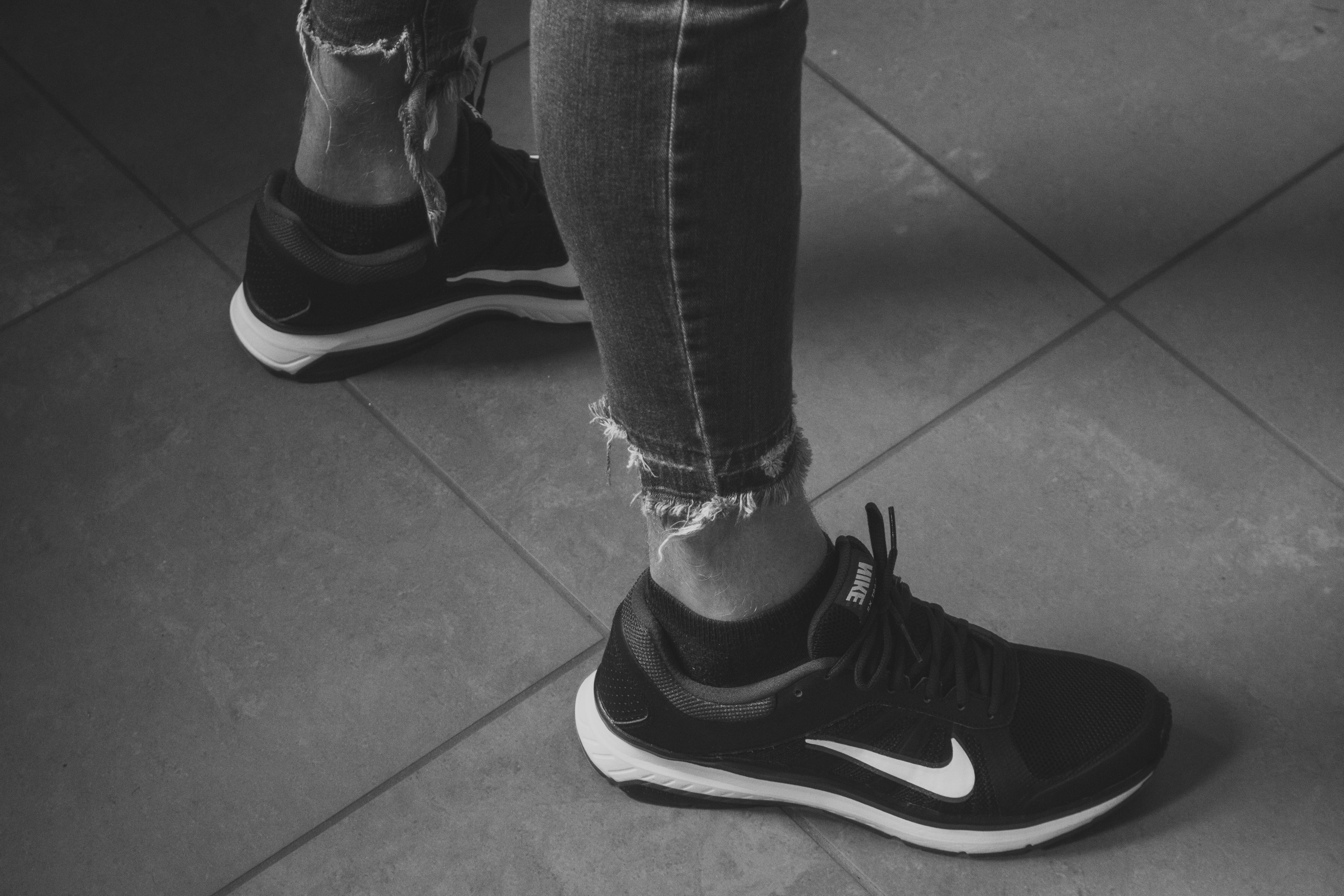 person in black nike running shoes