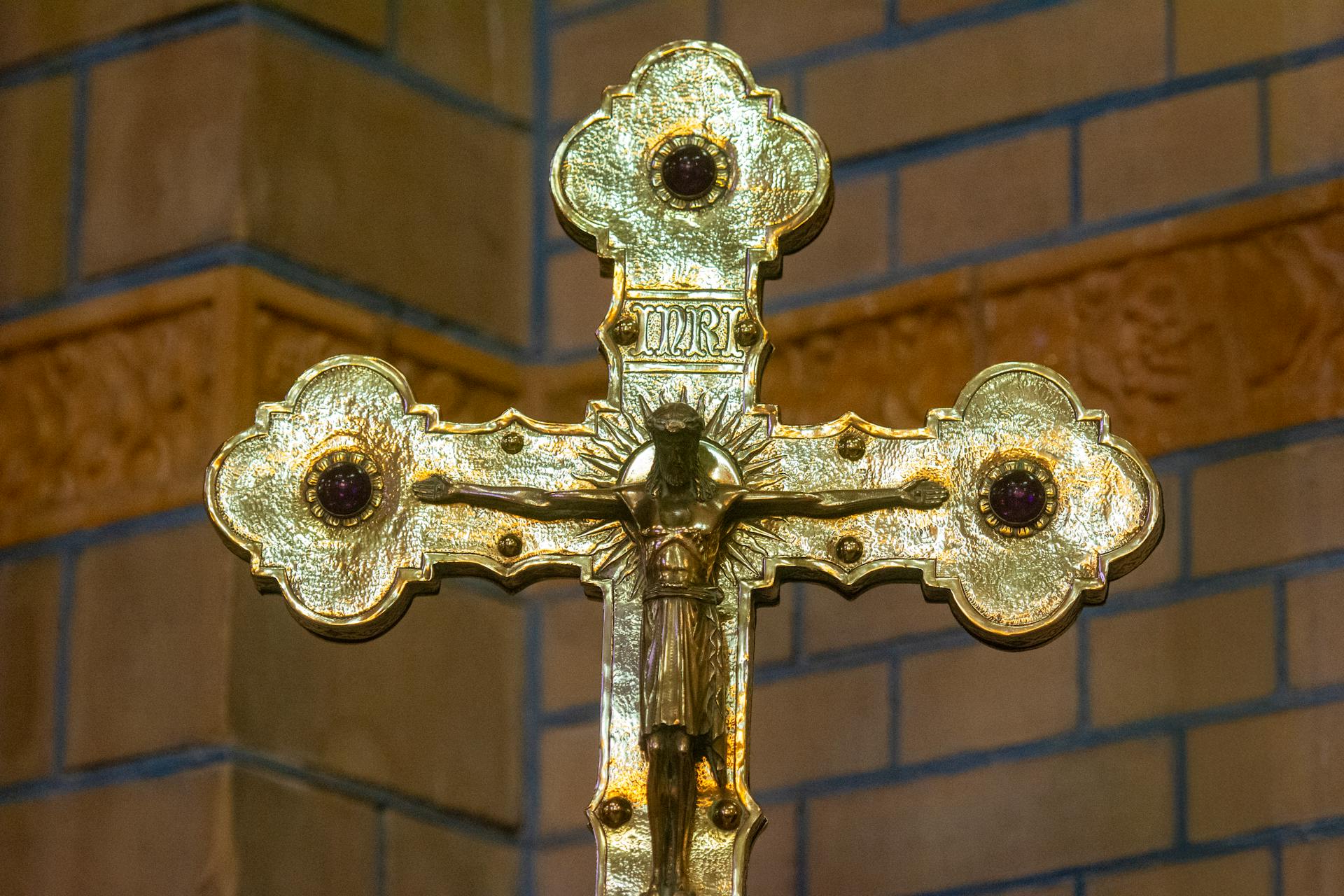 Close-up of an intricately designed golden crucifix in a church, symbolizing faith and spirituality.