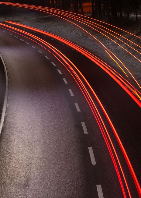 Captivating long exposure image showcasing car light trails on a highway at night, conveying motion. Captivating long exposure image showcasing car light trails on a highway at night, conveying motion.
