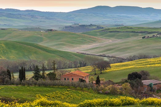 Beautiful Tuscan landscape with lush green hills and a rustic farmhouse.