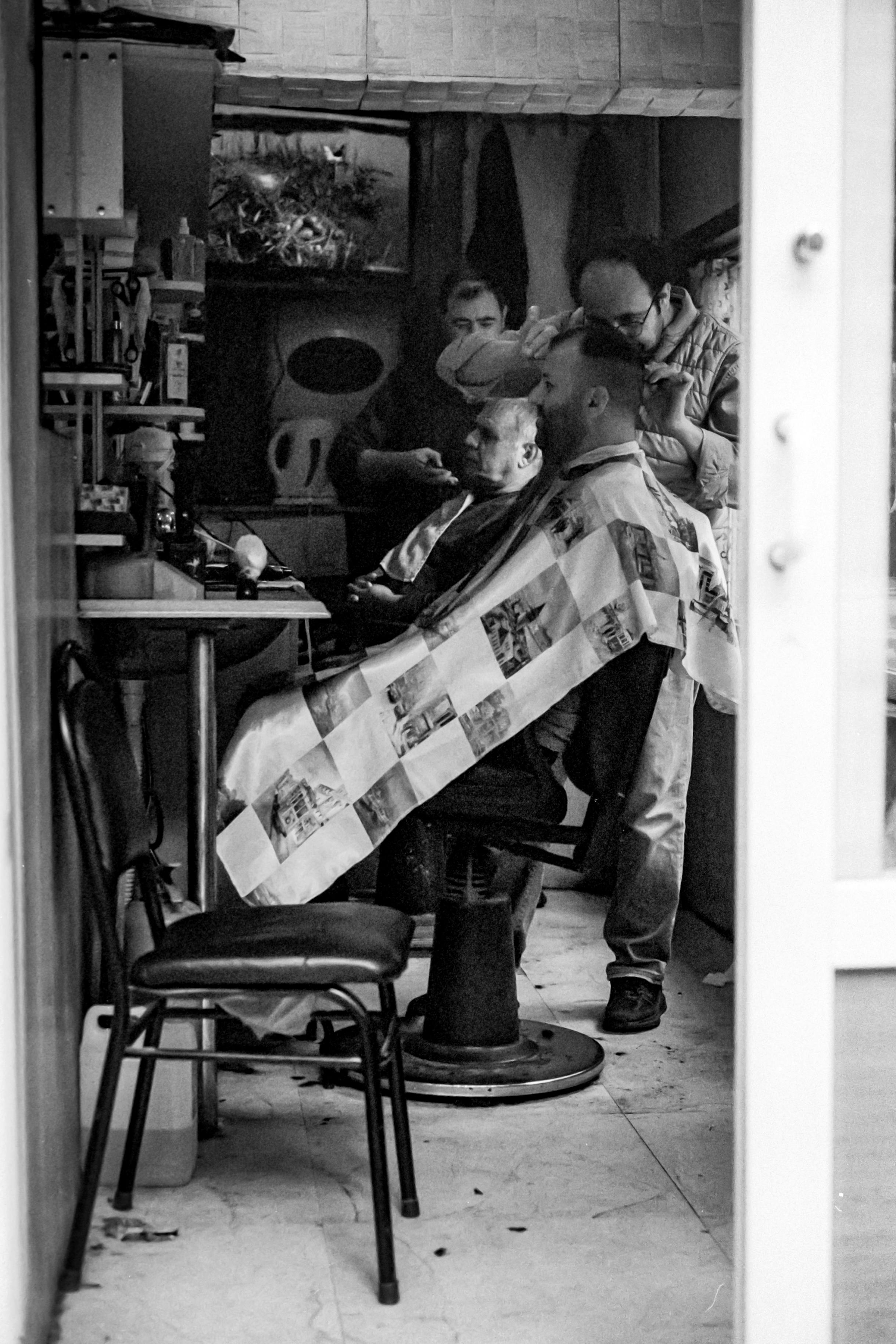 Charming barber shop scene in Istanbul, capturing daily life in black and white.
