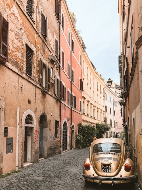 Brown Volkswagen Beetle Parked Outside Between Buildings