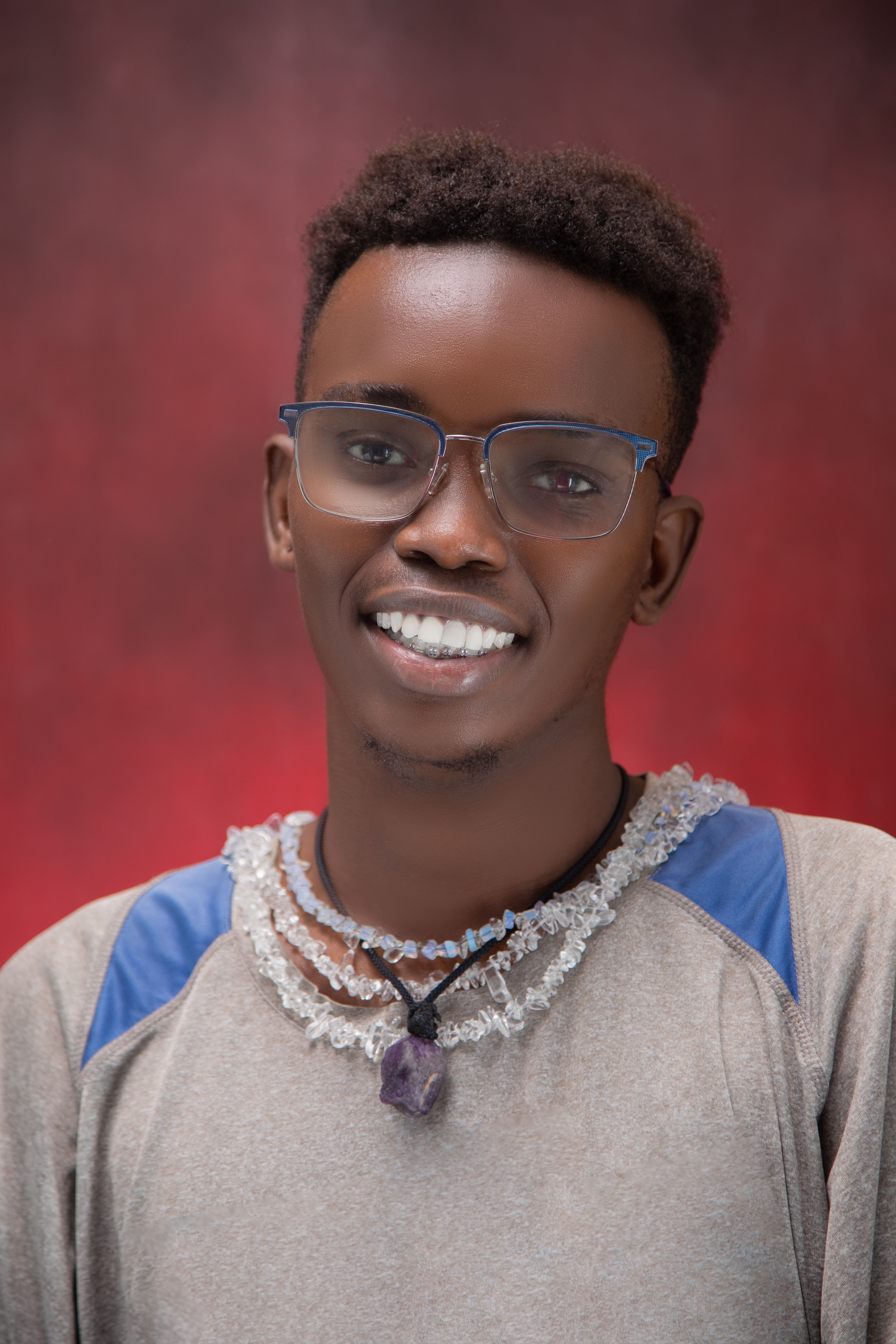 Portrait of a stylish young adult man smiling confidently with colorful background.