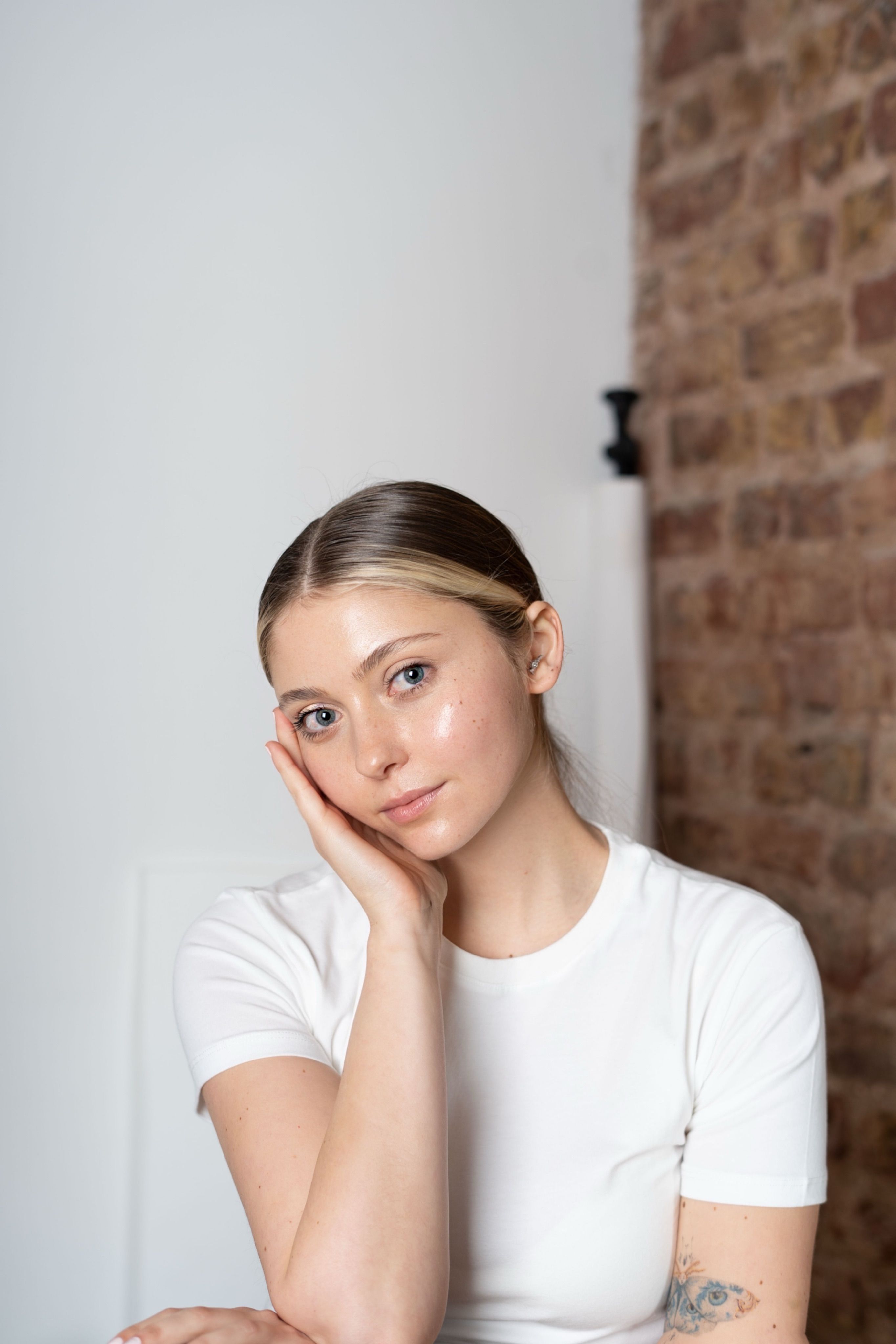 gratis Portret van een jonge vrouw met een nadenkende houding in een minimalistische setting. Stockfoto