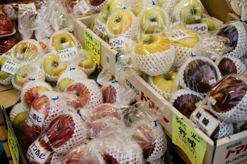 Free Vibrant display of fresh apples wrapped for sale at a local Japanese market. Stock Photo