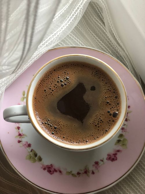 Free A steaming cup of coffee in a floral cup on a pink saucer, offering a warm and inviting feel. Stock Photo