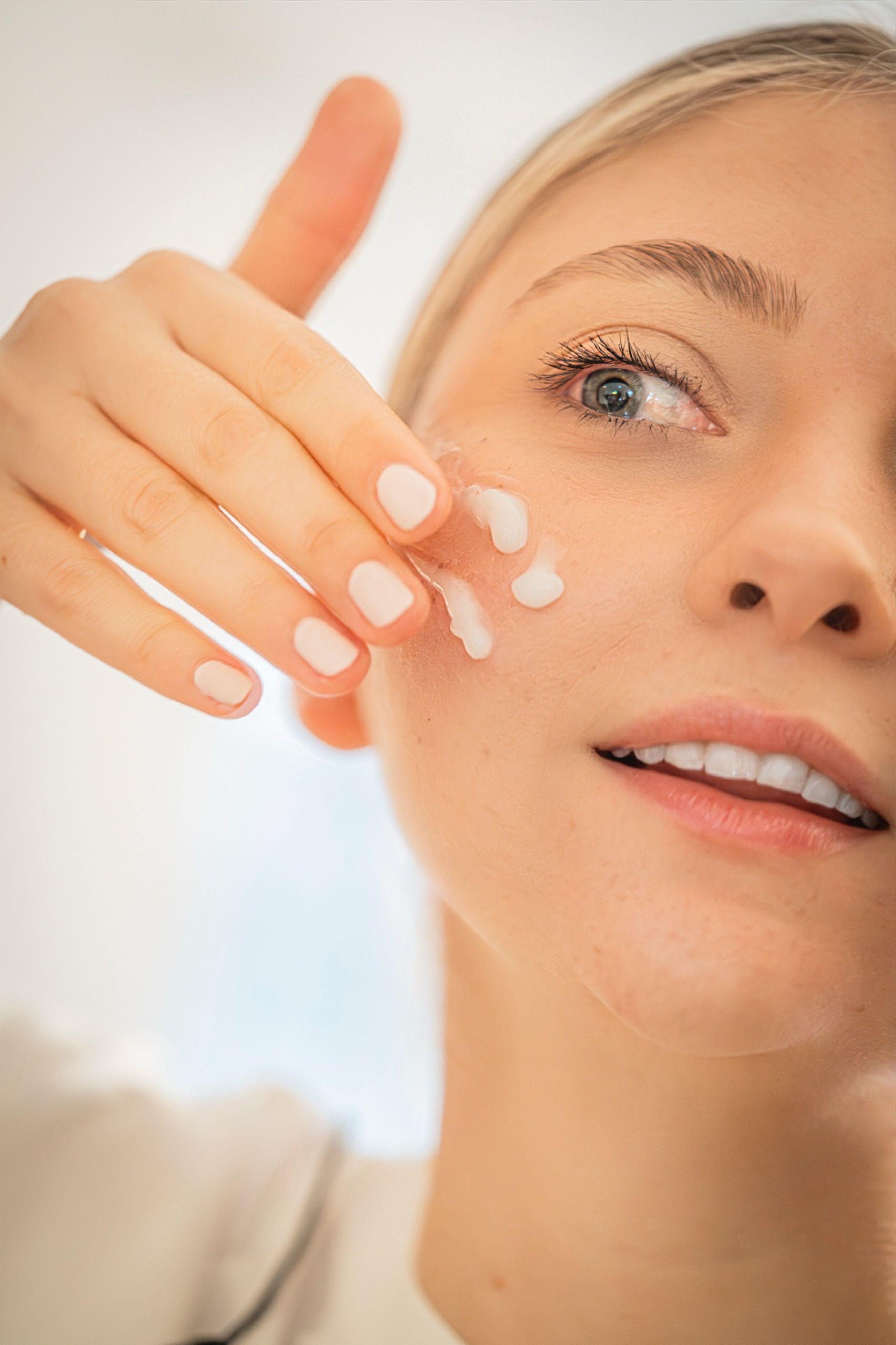 Gratuit Gros plan du visage d'une femme appliquant une crème hydratante, mettant en valeur sa routine de soins de la peau et sa peau saine. Photos