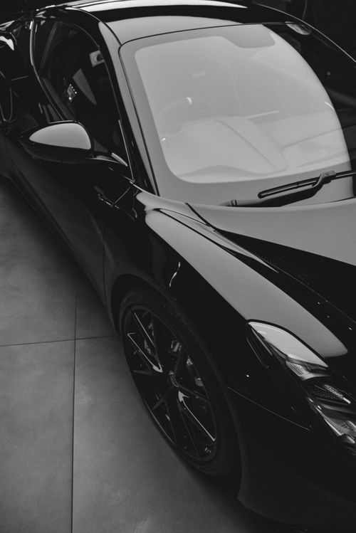 Free A stylish black sports car photographed in an indoor garage, showcasing luxury and design. Stock Photo