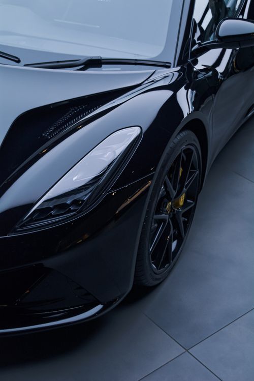 Free Close-up of a black luxury sports car with glossy finish on showroom floor. Stock Photo