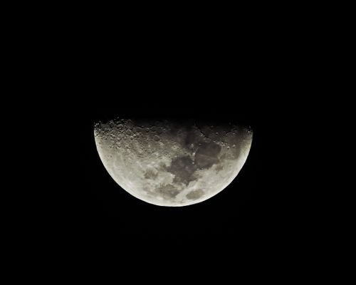 Free Captivating view of a half moon with detailed craters against a dark night sky. Stock Photo
