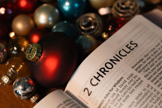 Open Bible showing 2 Chronicles surrounded by colorful Christmas ornaments.