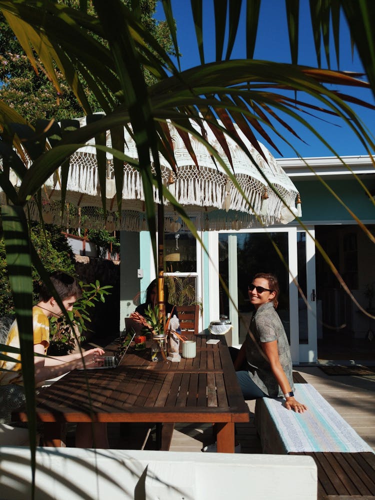 Person Sitting In Front Of Brown Wooden Table Outdoor