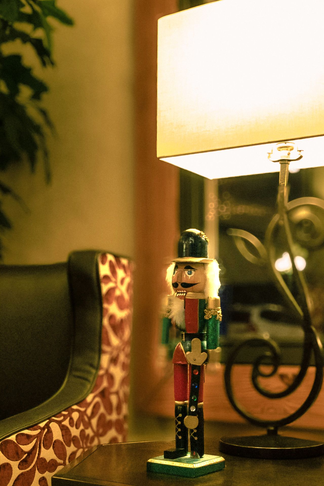 Warm indoor scene featuring a classic nutcracker next to an elegant lamp