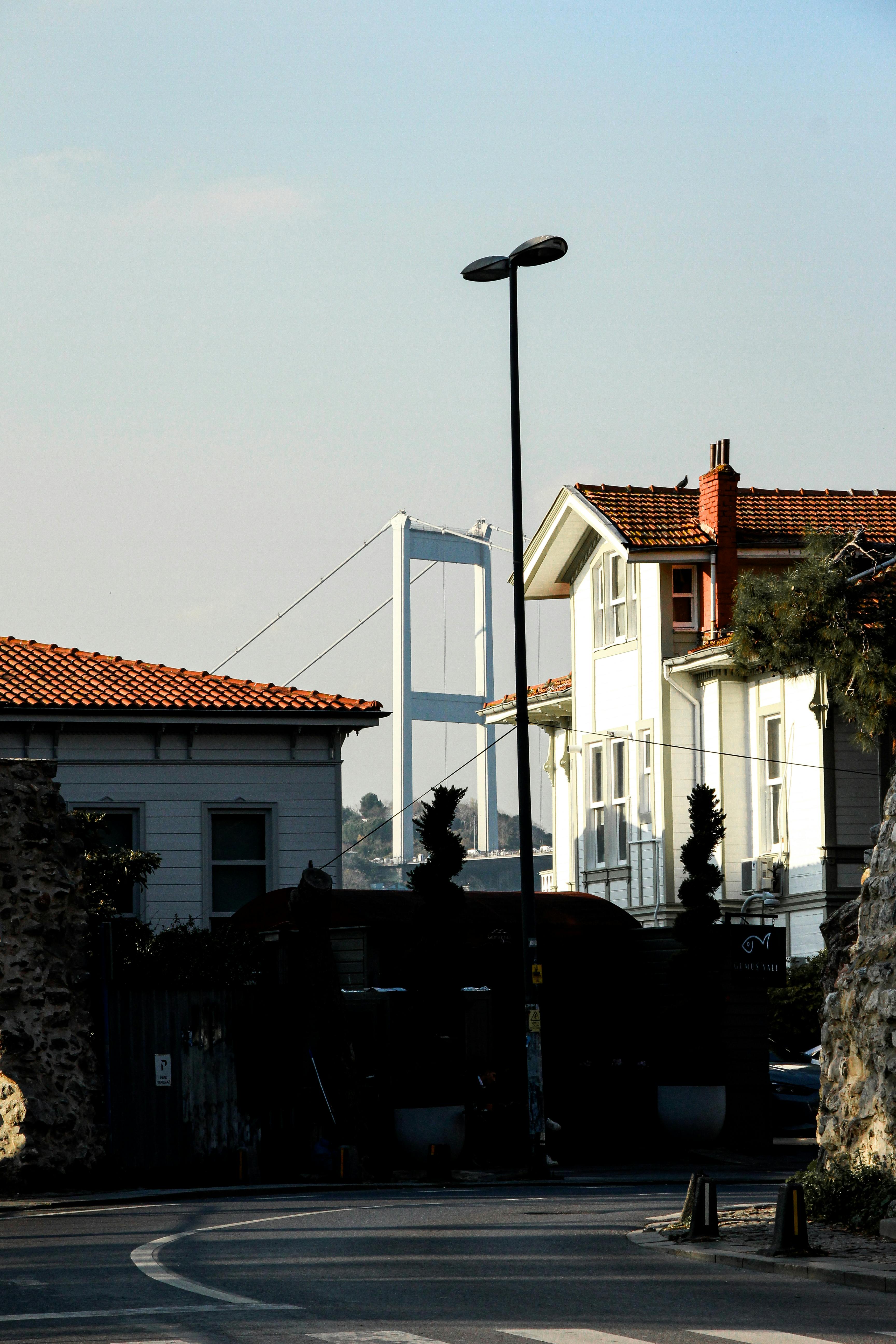 Scenic view of Bosporus Bridge from a charming street in Istanbul with traditional Turkish architecture.