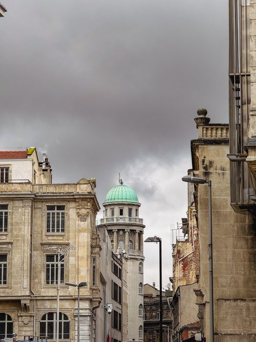 Free Street view of historic European buildings with a dramatic sky, showcasing urban architecture. Stock Photo