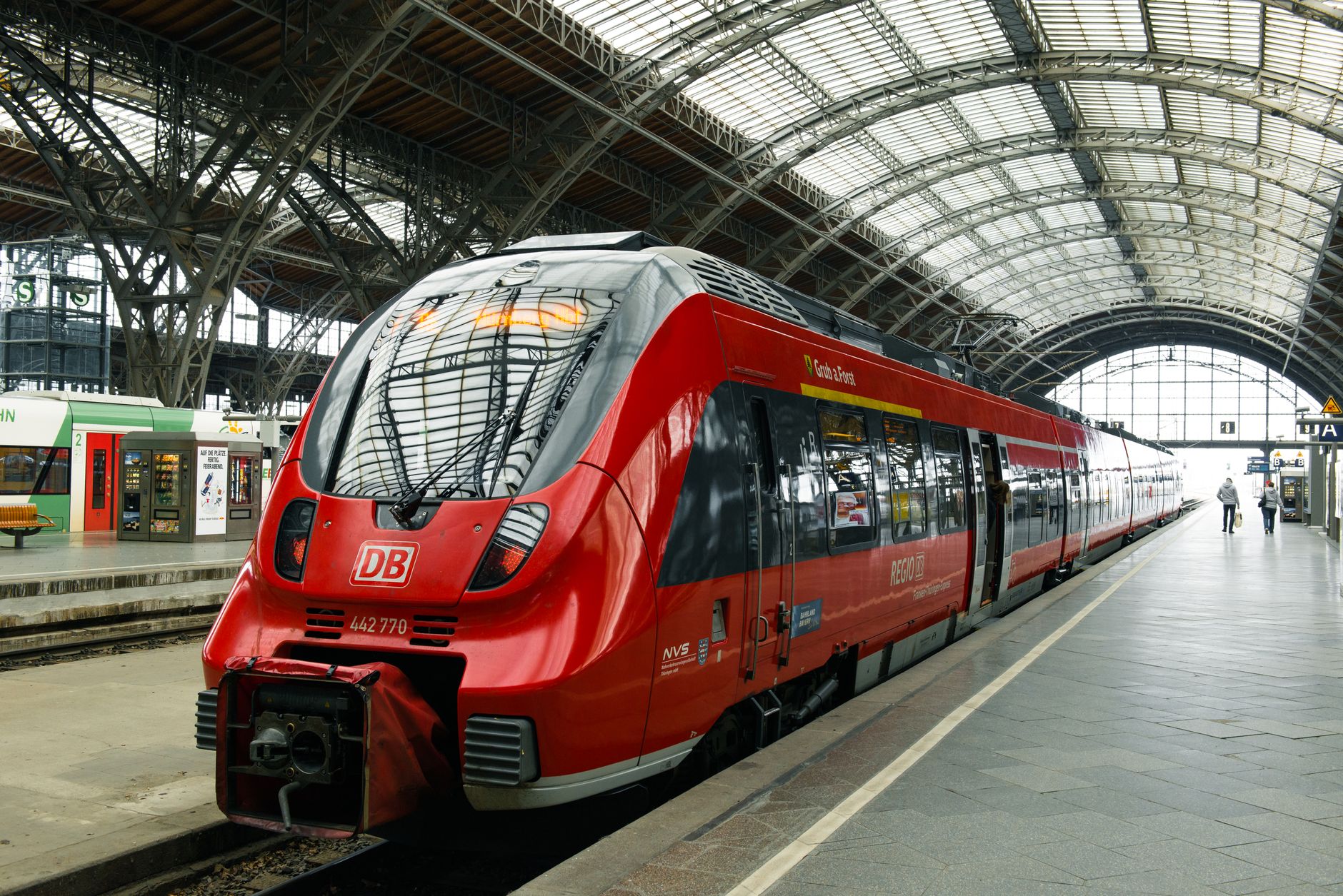 Modern red train at Leipzig Central Station with clear platform markings