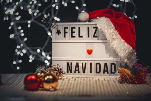 A holiday display featuring a 'Feliz Navidad' lightbox adorned with a Santa hat and Christmas decorations.