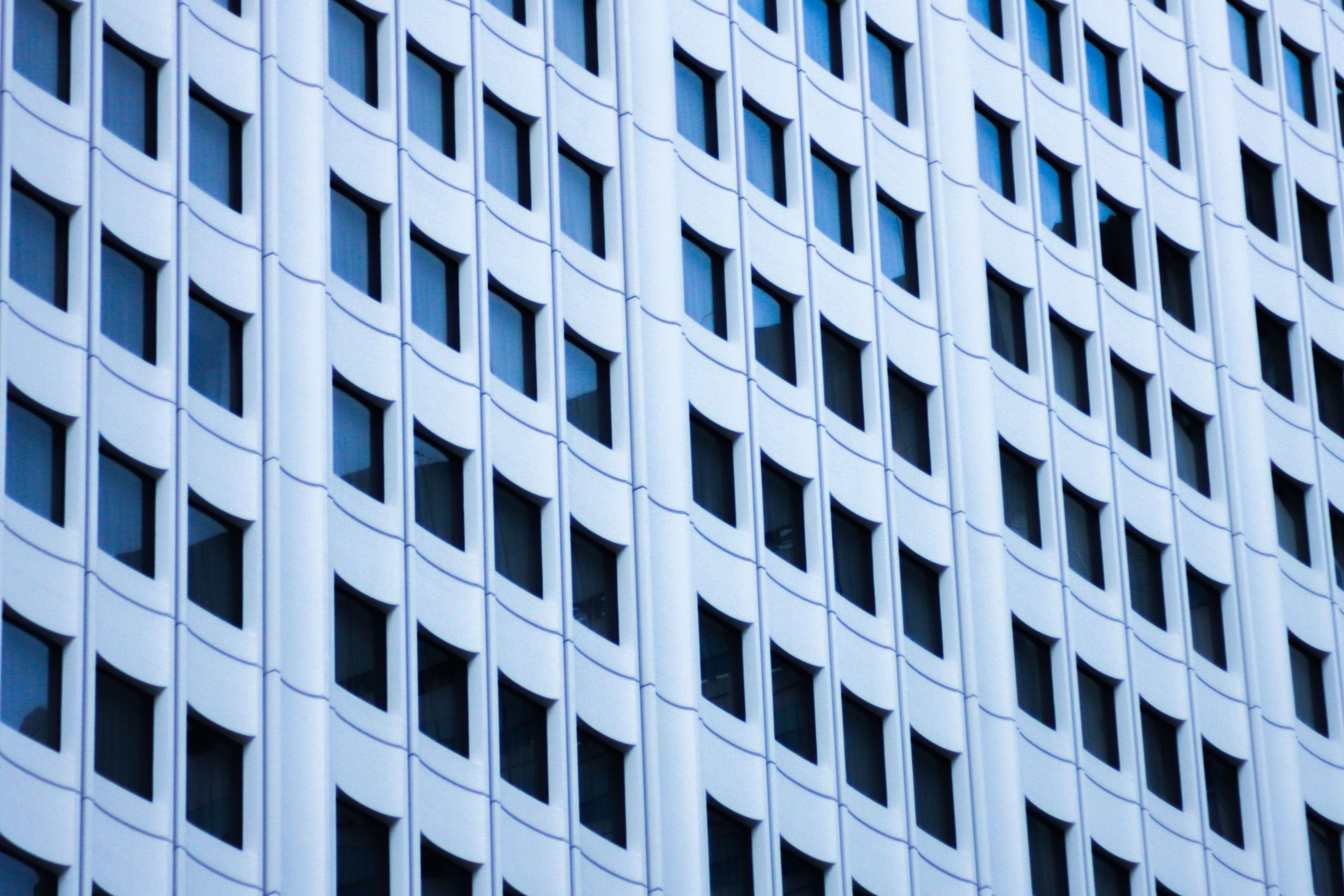 Close-up of a modern skyscraper facade in New York City featuring a grid of windows and geometric patterns.