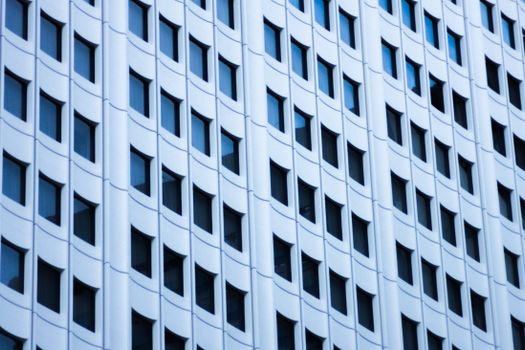 Close-up of a modern skyscraper facade in New York City featuring a grid of windows and geometric patterns.