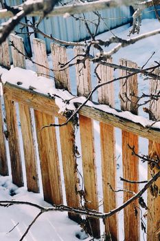 A rustic wooden fence covered in snow, capturing winter in Talgar, Kazakhstan.