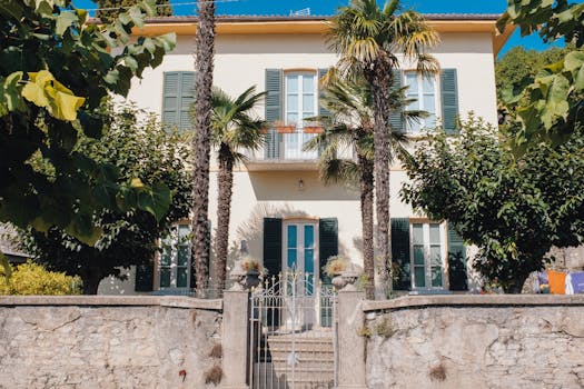 Charming Mediterranean-style villa surrounded by lush greenery and palm trees.