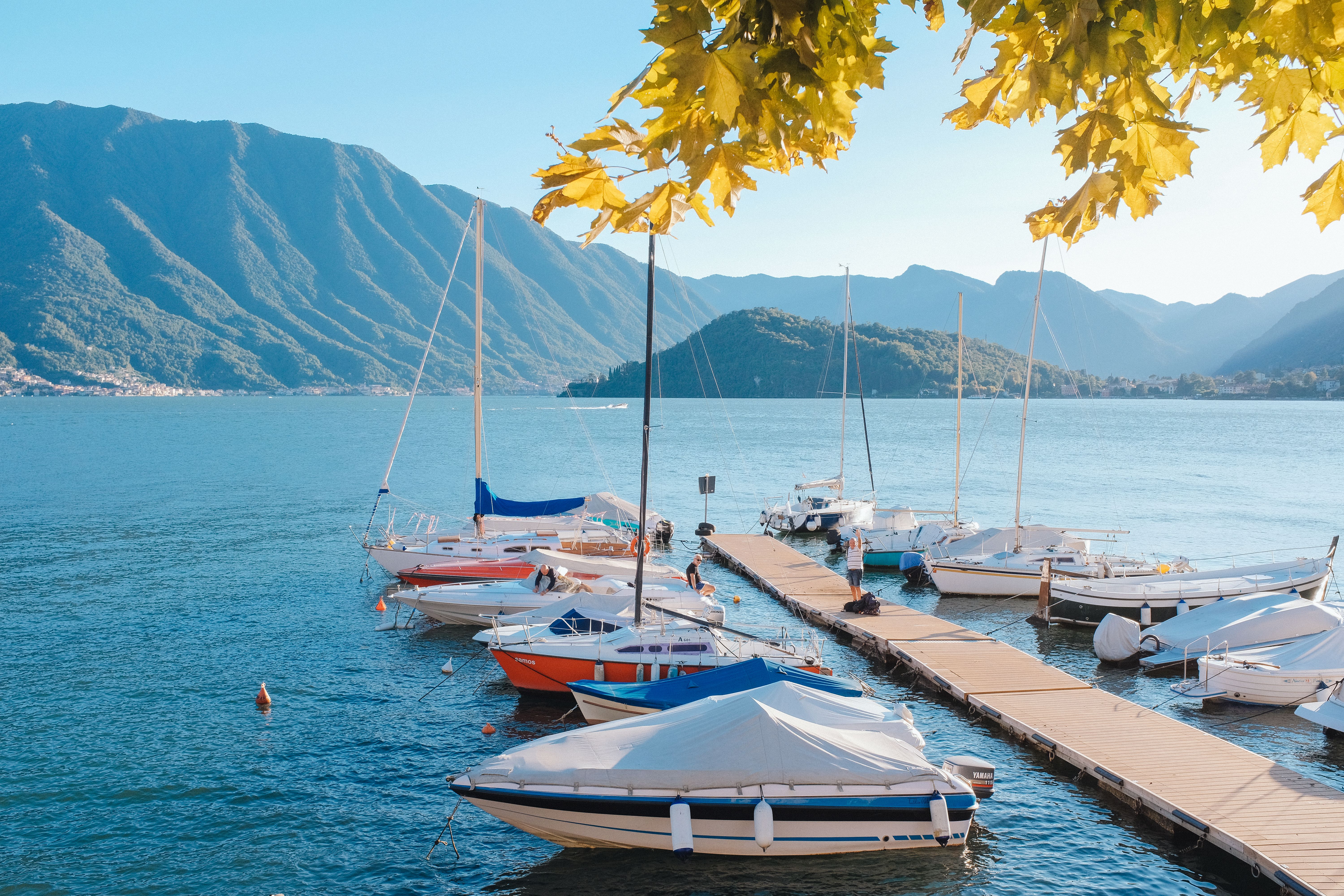 Amazing Tour of Ischia Island with Motor Yacht Rocca Corsa Review: 7 Hours of Italian Paradise Review 2026 - A tranquil lakeside view with moored boats and a stunning mountainous backdrop on a sunny day.