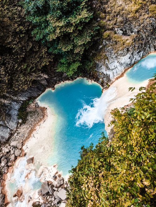 Free Aerial view of a vibrant blue waterfall surrounded by lush greenery in Giresun, Türkiye. Stock Photo