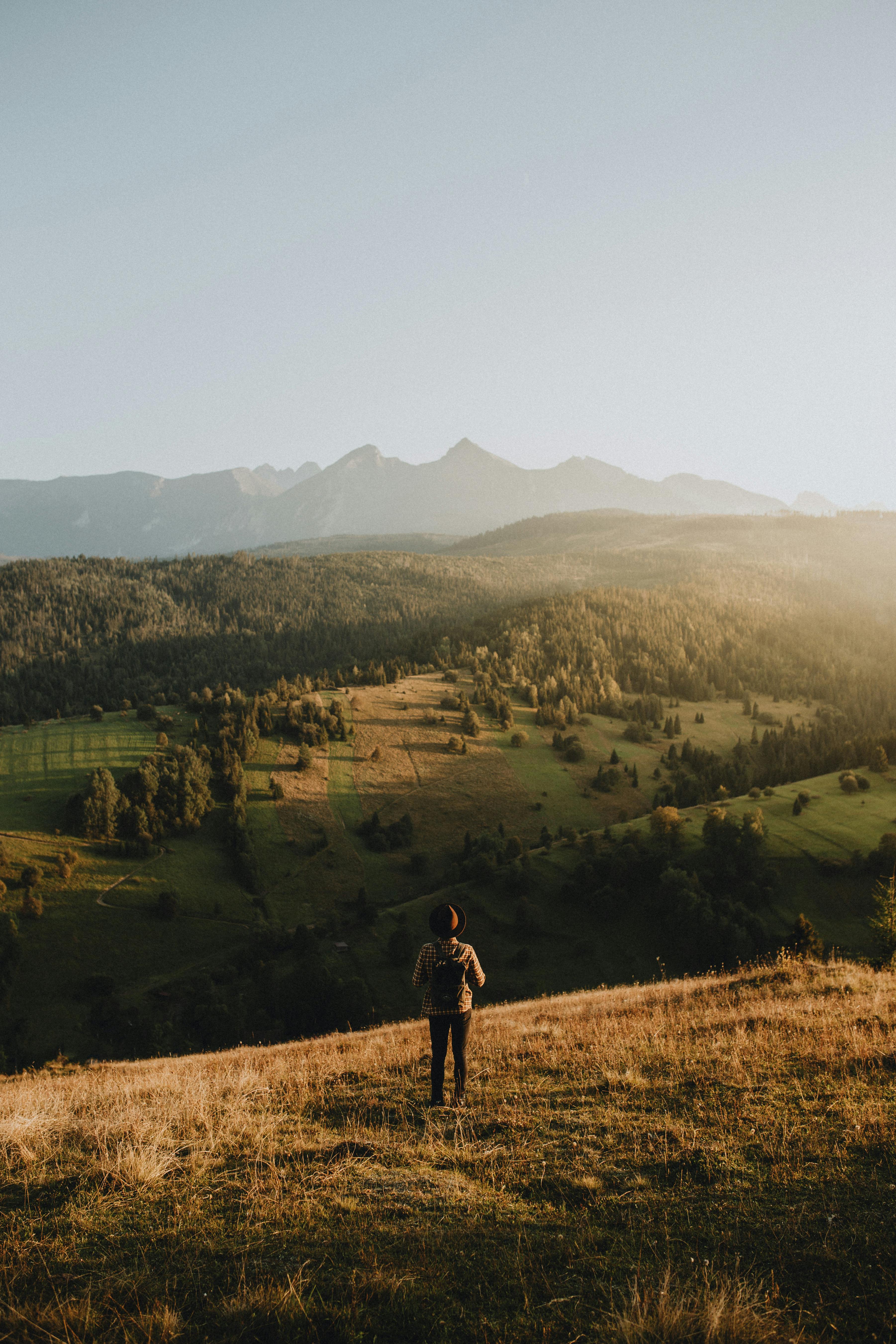 A lone hiker enjoys a stunning sunset view over the Vysoké Tatry mountains in Slovakia's Prešov Region.