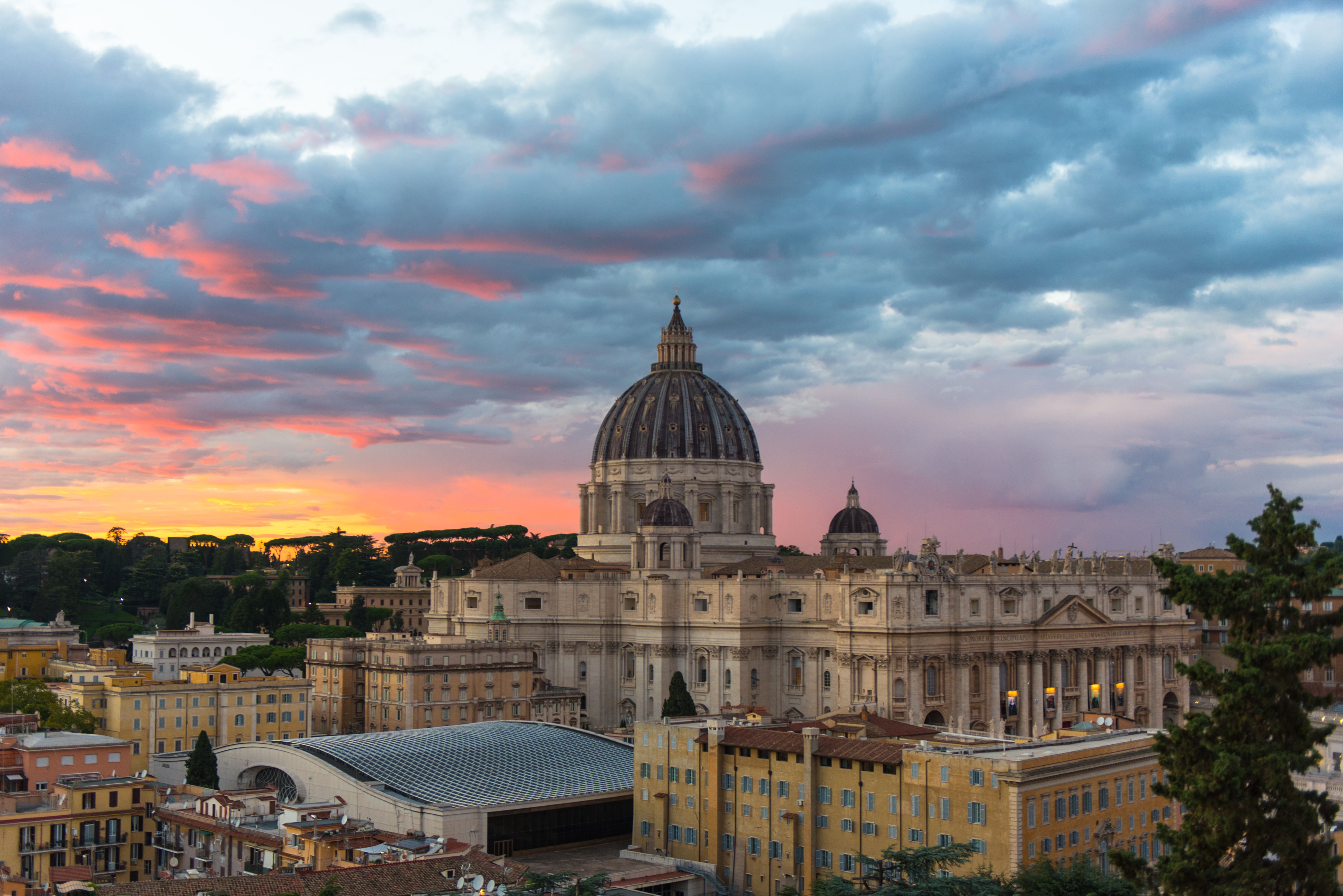 Beautiful view of St. Peter's Basilica at sunset with vibrant clouds in Vatican City.
