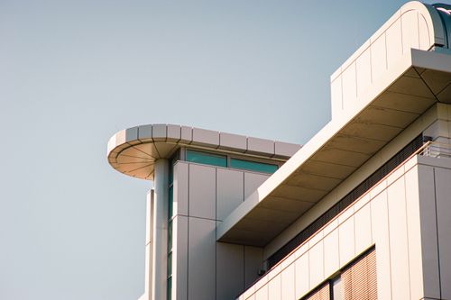 Free A contemporary building featuring geometric design elements under a clear sky, showcasing modern architecture. Stock Photo