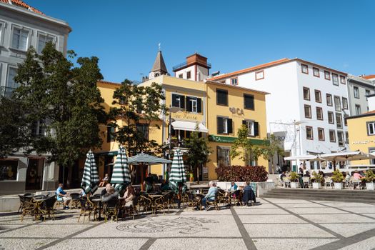 Quaint outdoor café in Funchal, Madeira on a sunny day, perfect for leisurely dining.