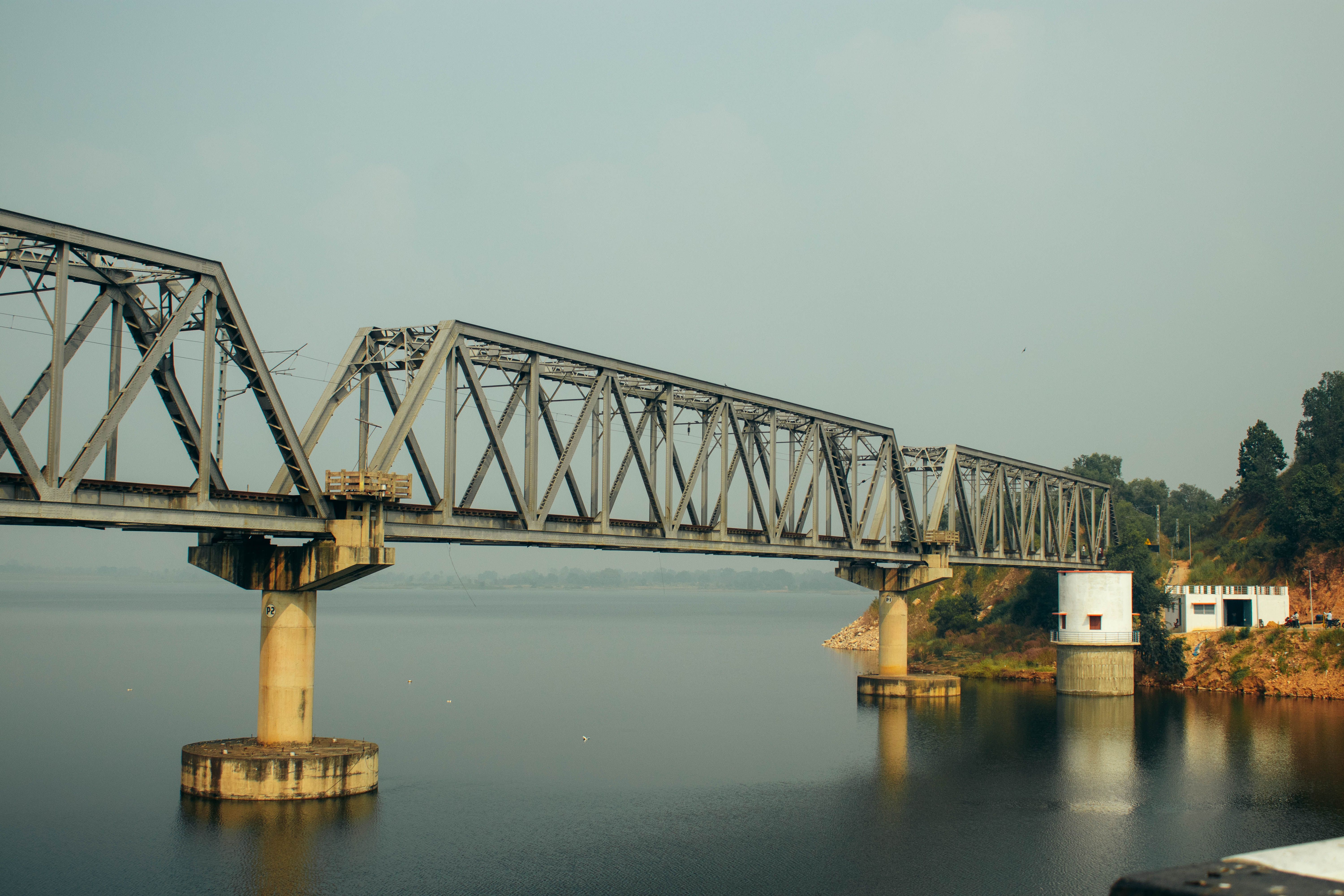 Steel Bridge over Calm River in Natural Setting · Free Stock Photo