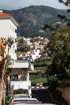 Discover the picturesque streets of Madeira, Portugal, set against a lush mountain backdrop.