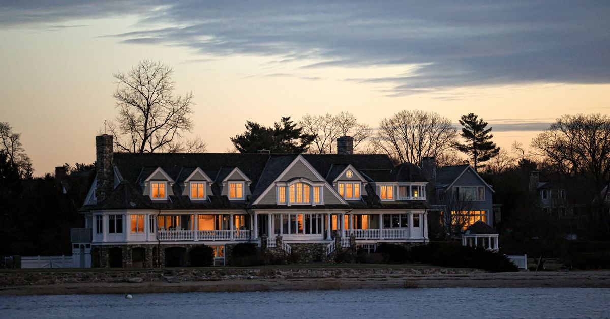 Elegant waterfront home in Stamford, Connecticut, captured at twilight with glowing windows and serene surroundings.