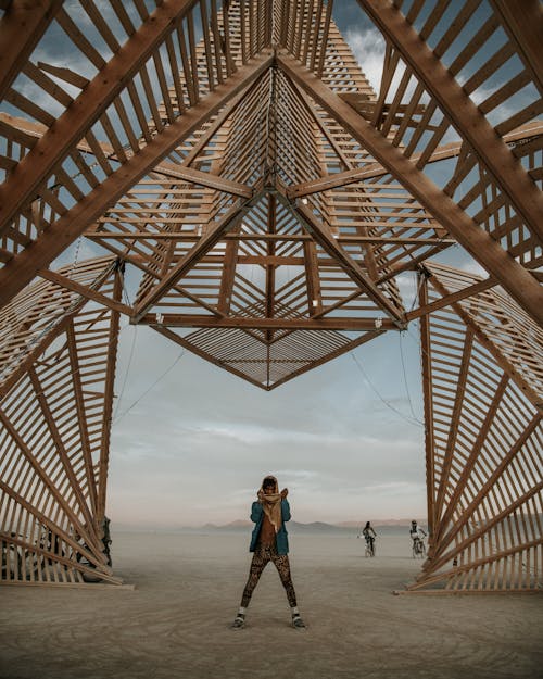 Человек, стоящий под деревянной конструкцией