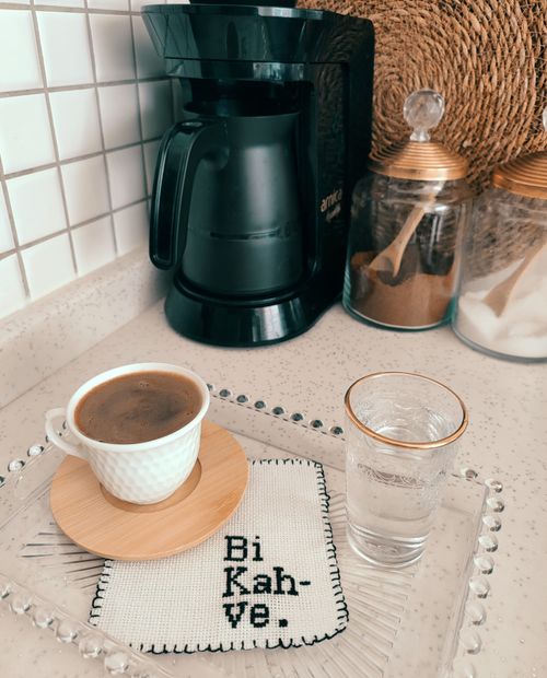Free Warm coffee setup with a coffee maker, cup of coffee, and jar of sugar in a kitchen setting. Stock Photo