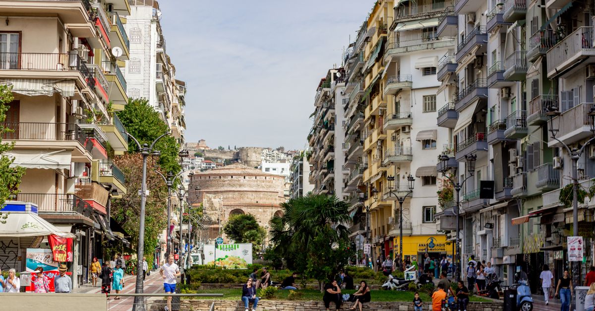 Bustling street scene in Thessaloniki, Greece with historic Rotunda in the background.