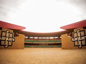 A modern, colorful arena in Niger with a vast sand floor, ideal for events.