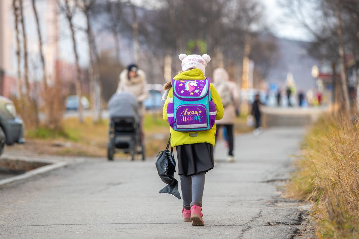 Un enfant portant son sac à dos sur le chemin de l’école