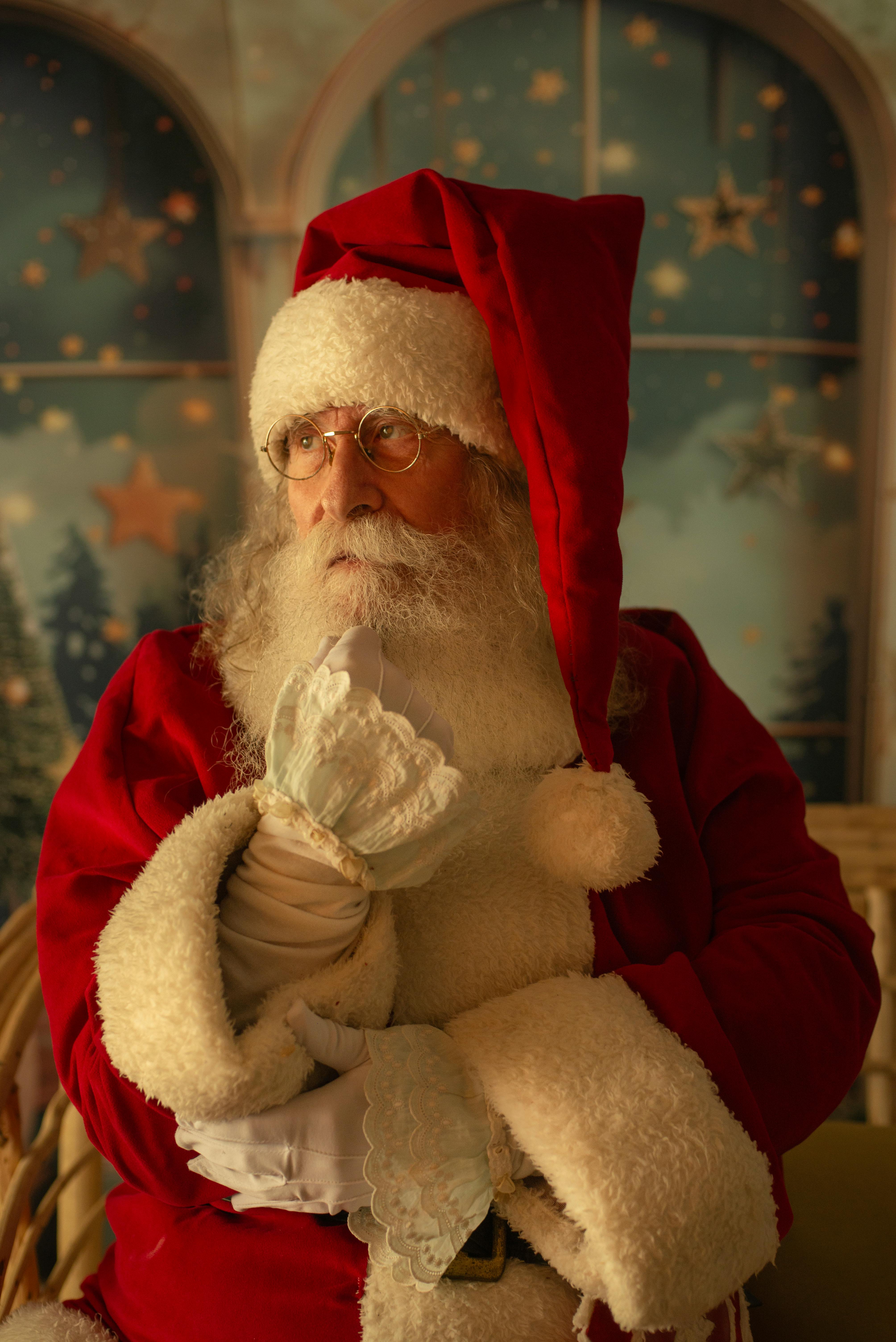 Santa Claus in a cozy room pondering, surrounded by a festive, starry background.