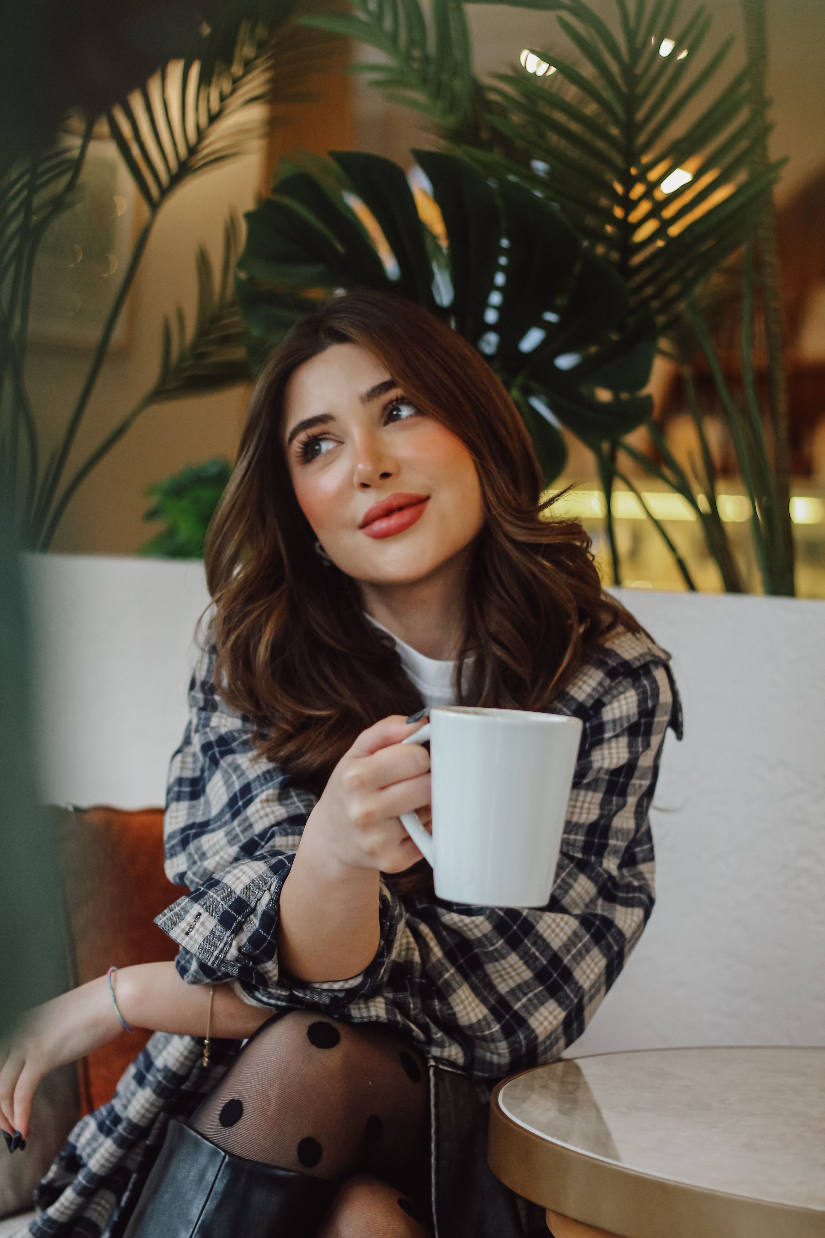 Relaxed Woman Sipping Coffee in Cozy Cafe · Free Stock Photo