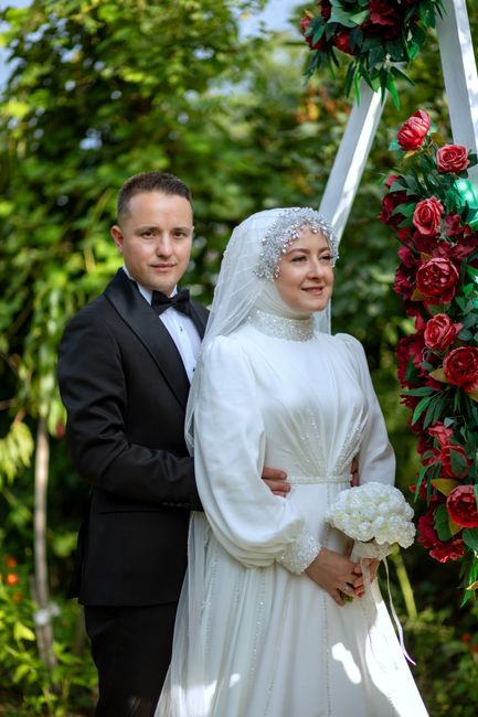 2026 Gelinlik Modası: 2026’da Düğün Şıklığının Yeni Yüzü 2 A bride and groom pose beautifully in a lush garden setting on their wedding day.