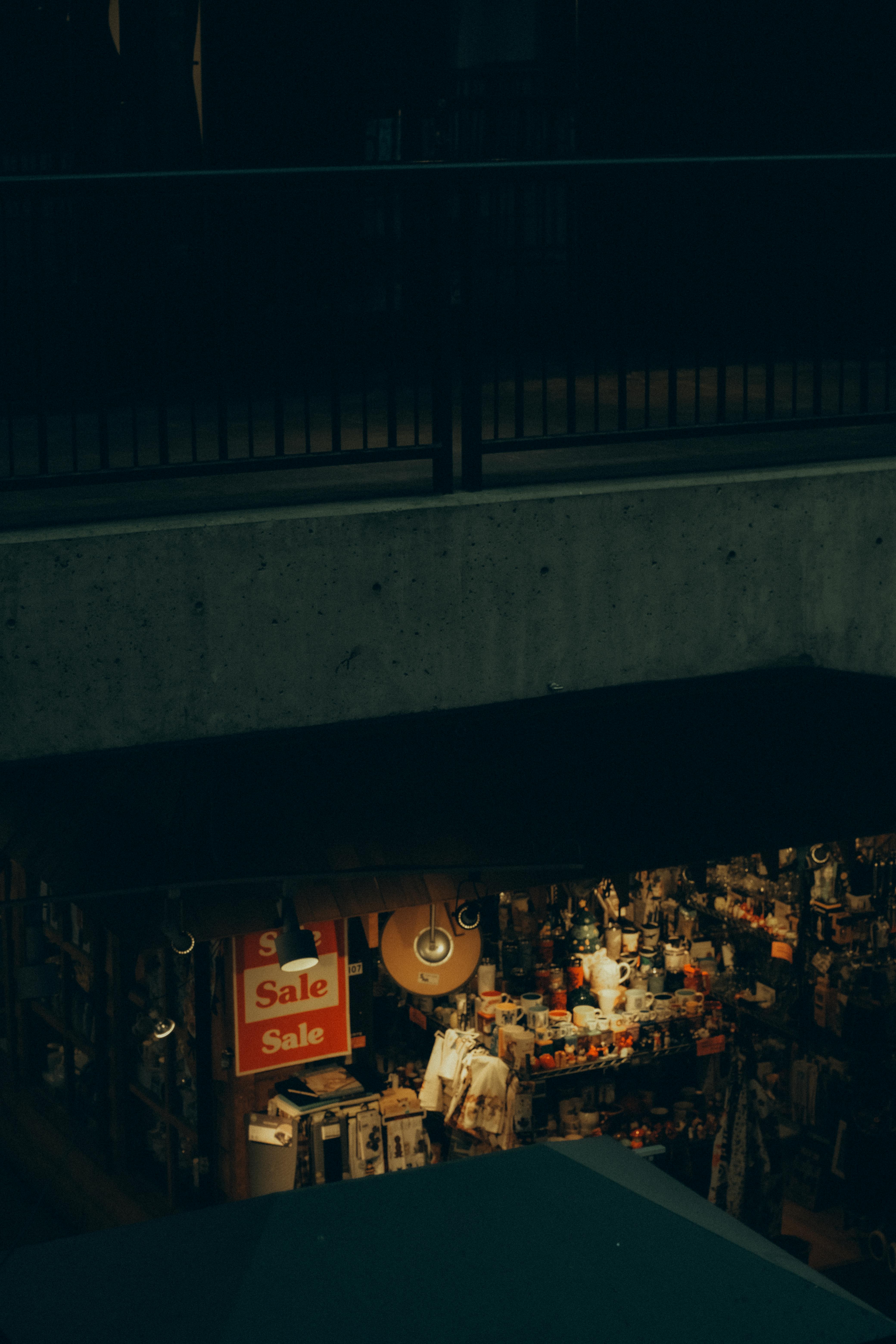 A cozy antique shop interior with warm lighting and sale signs visible from above.