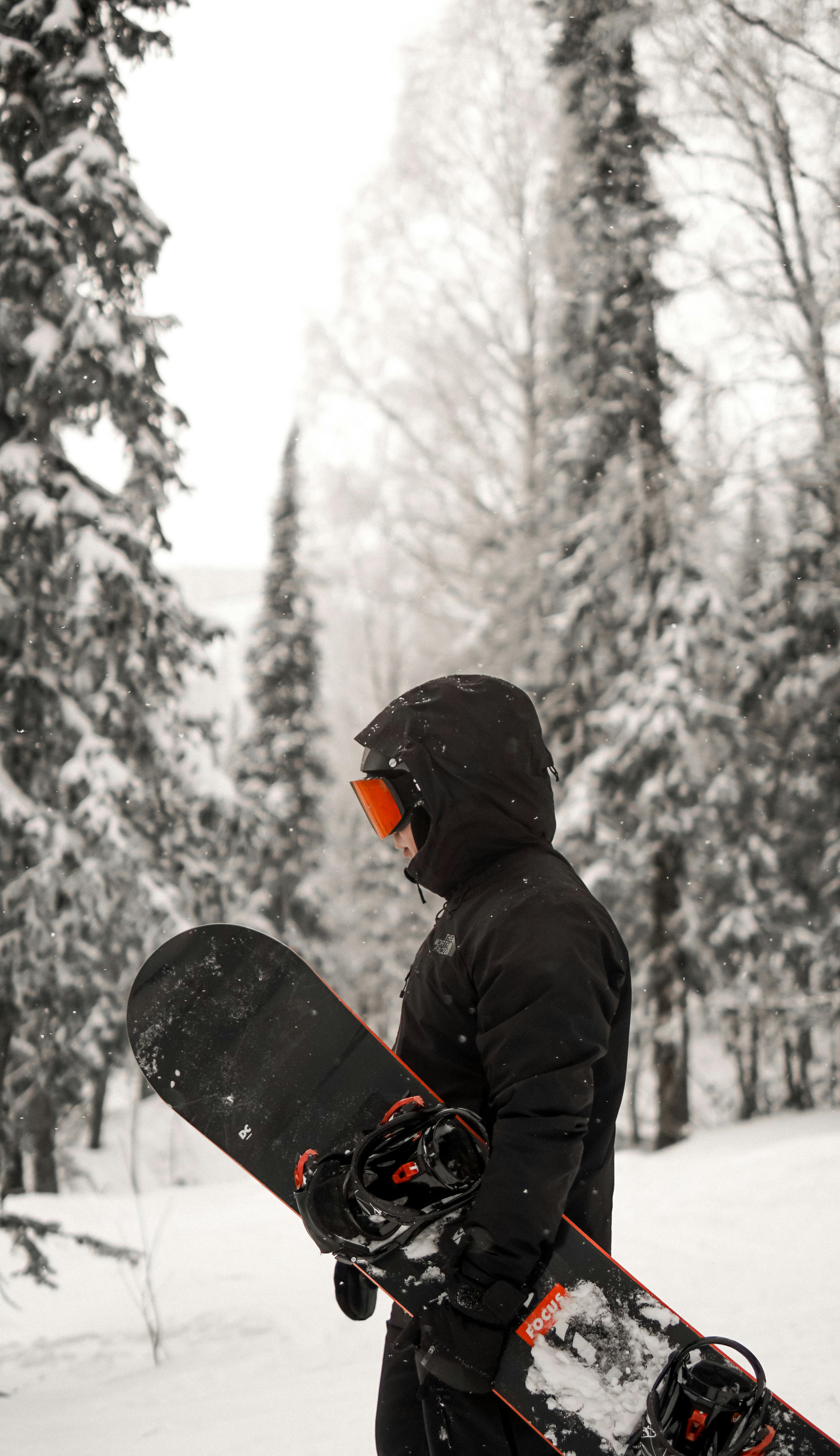 Prescription Goggle Inserts - A snowboarder in full gear stands amidst a snowy forest, showcasing winter adventure.