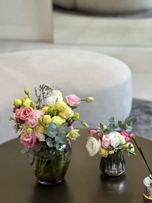 Free Stylish floral arrangements in vases on a sleek modern table, adding elegance to the interior decor. Stock Photo