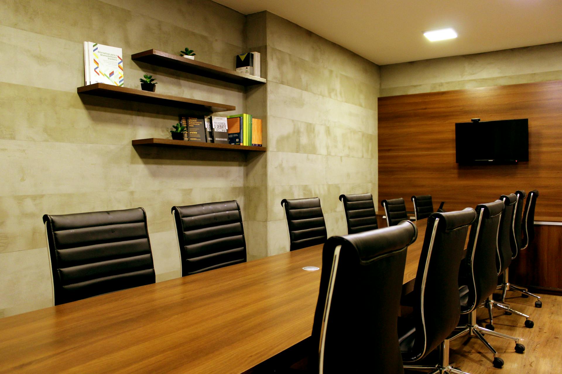 Elegant boardroom with leather chairs and wooden decor, ideal for meetings.