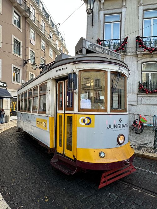 Free Capture of a classic Lisbon tram on a cobblestone street, Portugal. Stock Photo